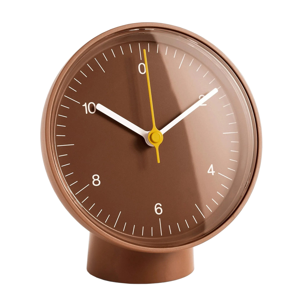 A modern round table clock with a warm brown face and matching brown base, featuring white numerals and hands with a yellow second hand, isolated on a white background.