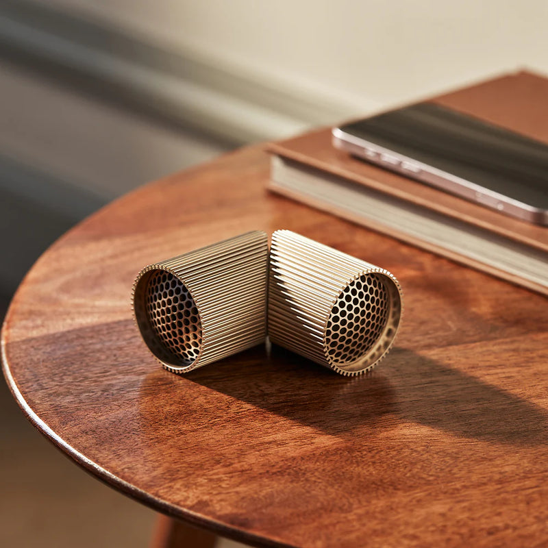 Two cylindrical cardboard cat toys on a wooden table with a blurred background